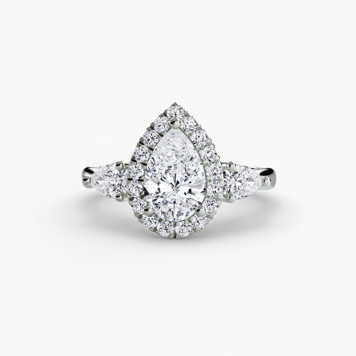 Front view of The Clarimond three-stone halo engagement ring with pear-shaped side diamonds
